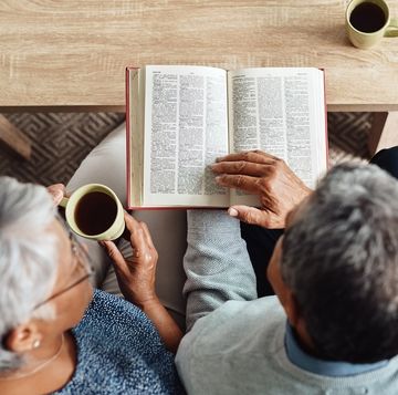 bible verses about love older couple sitting on a couch together reading the bible