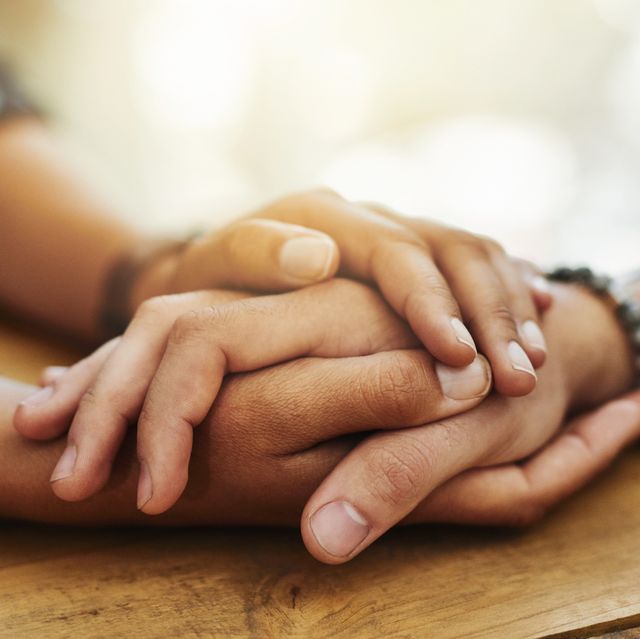 closeup shot of two unrecognizable people holding hands in comfort