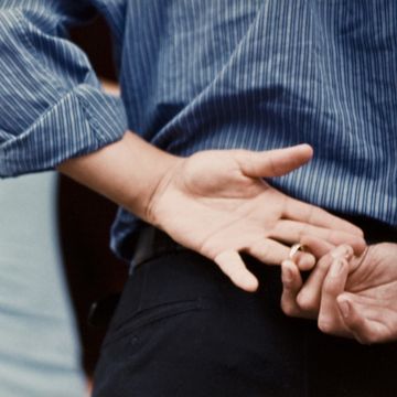 signs partner is cheating  man pulling off wedding band behind his back