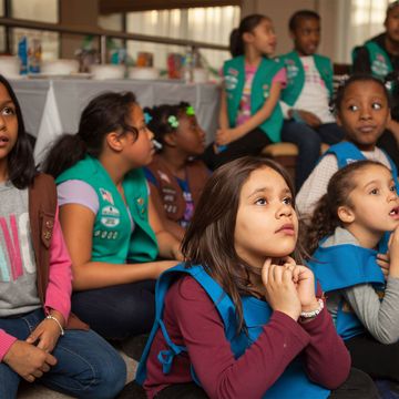 Girl scout troop listens at a meeting.