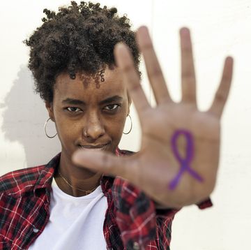 black woman with international women's day ribbon on hand